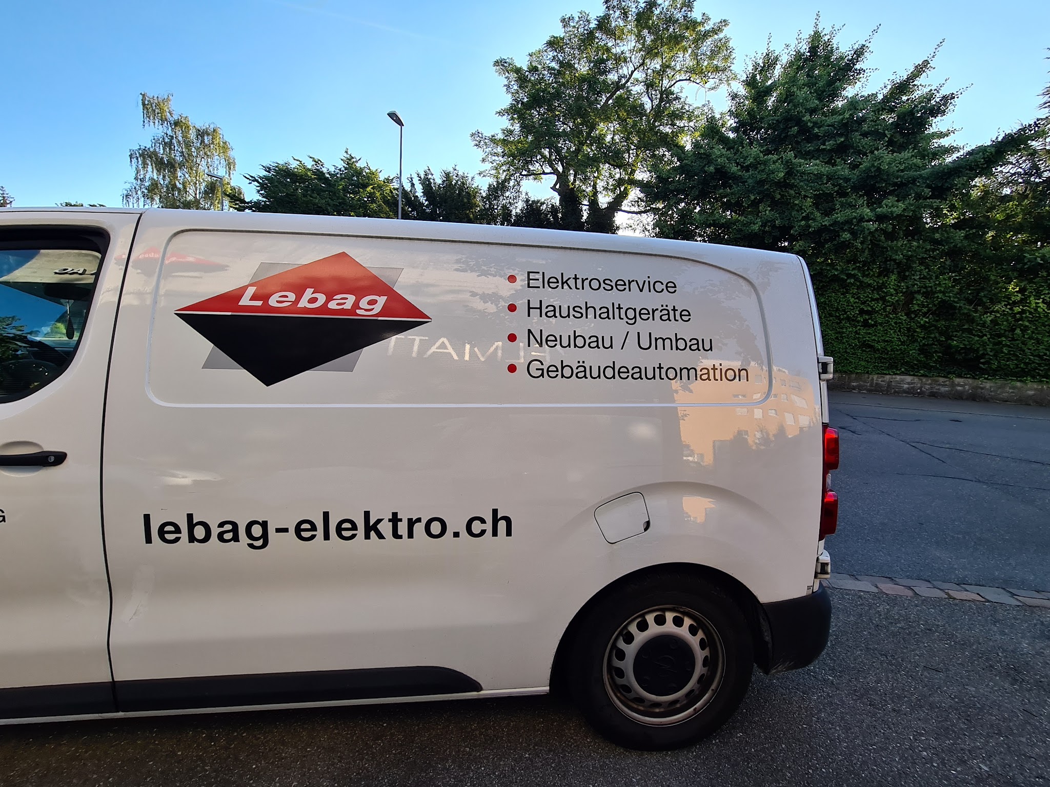Weisser Lebag-Lieferwagen mit Logo und der Leistungsliste Elektroservice, Haushaltgeräte, Neubau / Umbau, Gebäudeautomation
