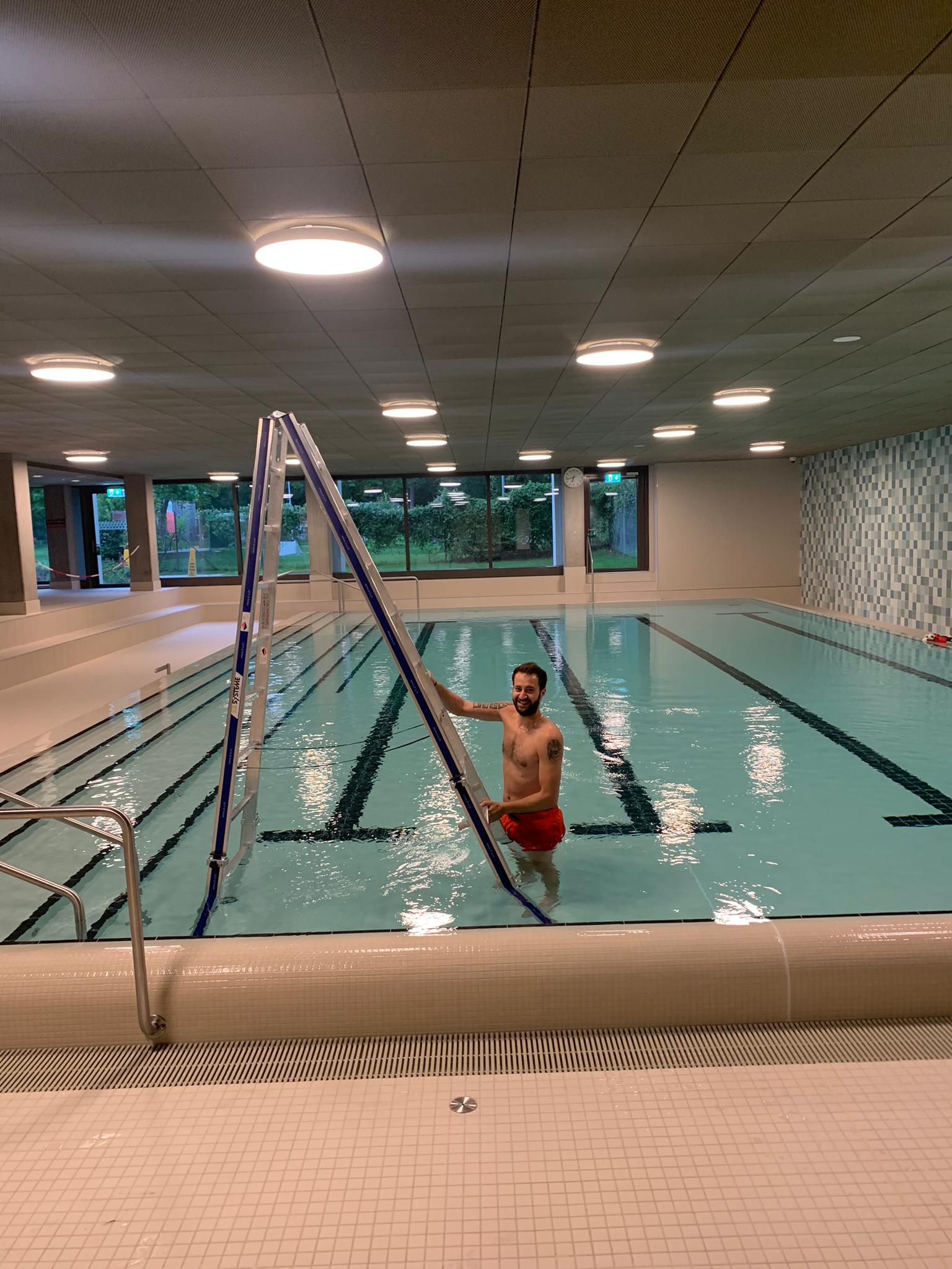 Hallenbad mit Schwimmbecken, in dem die Deckenbeleuchtung kontrolliert wird
